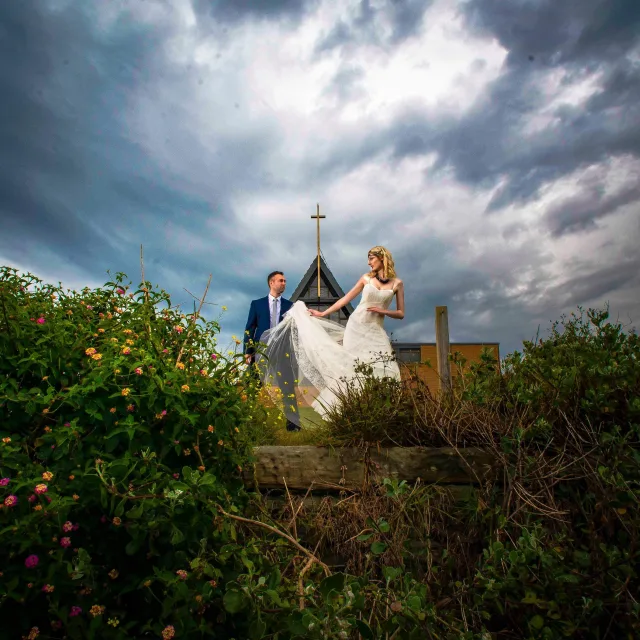 Bride and groom photographed together at Little Bay Chapel in Sydney on their wedding day.